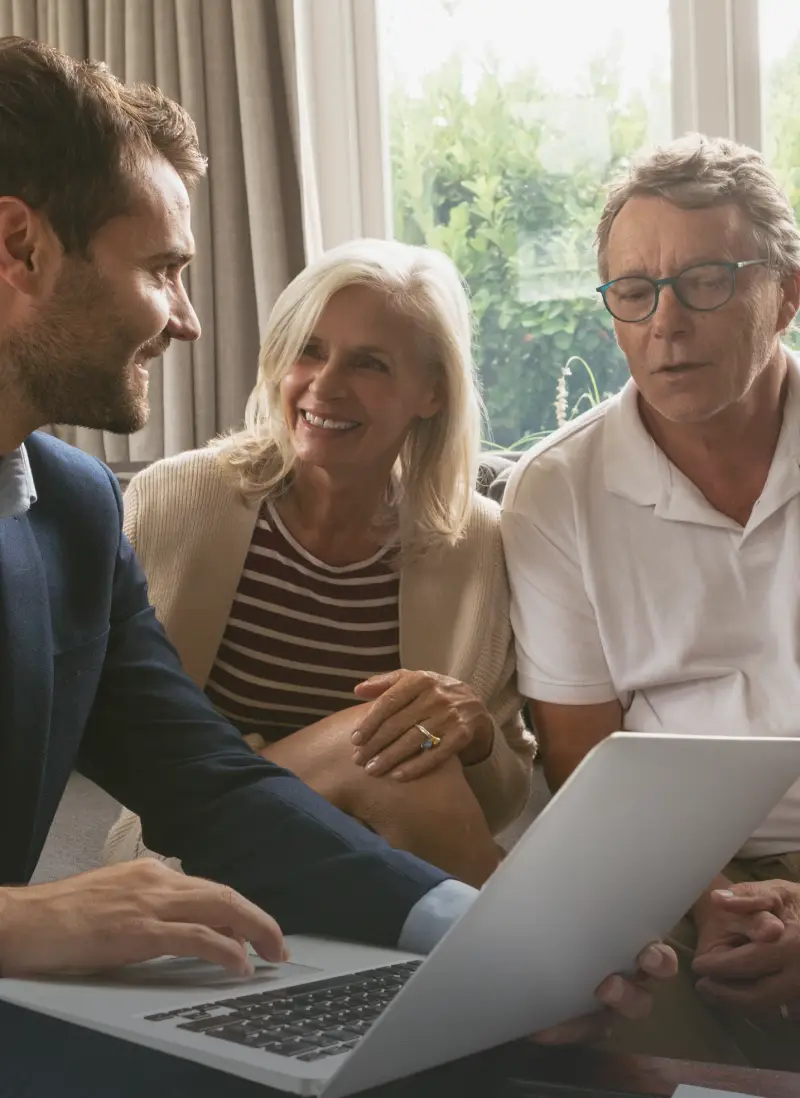 Couple meeting with real estate consultant to discuss property advice on a laptop.